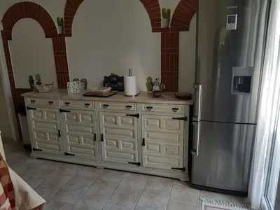 a kitchen with a stainless steel refrigerator and cabinets at Villa La Milouyette in Peyriac-Minervois