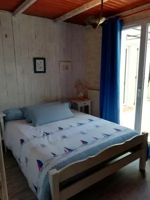 a bedroom with a bed with a blue curtain at Villa La Milouyette in Peyriac-Minervois