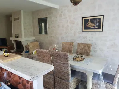 a dining room with a white table and wicker chairs at Villa La Milouyette in Peyriac-Minervois