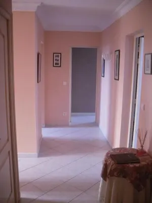 a hallway with pink walls and a room with a table at Domaine de la Pendule in Issel