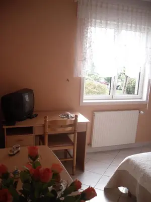 a bedroom with a table and a desk and a television at Domaine de la Pendule in Issel