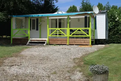 a green and white house with a porch at Parc Des Oliviers in Gaudiès