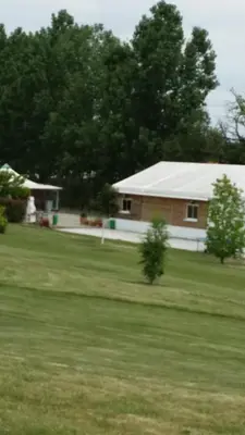 a house with a white roof and a grass field at Parc Des Oliviers in Gaudiès