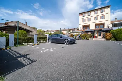 a car parked in a parking lot next to a building at Hôtel Restaurant du Lauragais LOGIS DE FRANCE in Villefranche-de-Lauragais