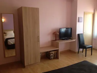 a small room with a television and a bedroom at Hôtel Restaurant du Lauragais LOGIS DE FRANCE in Villefranche-de-Lauragais