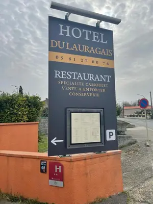 a sign for a hotel with a sign for a hotel downtown at Hôtel Restaurant du Lauragais LOGIS DE FRANCE in Villefranche-de-Lauragais