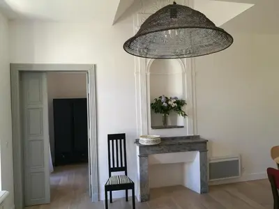a room with a fireplace and a chandelier at Gîte Maison de l'Abbé in Sorèze