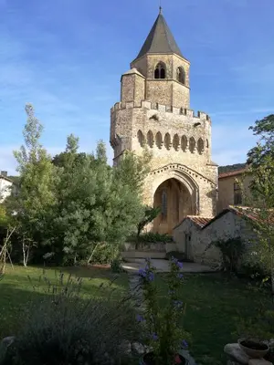 an old building with a tower in a yard at Gîte Maison de l'Abbé in Sorèze