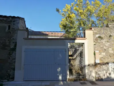 a garage door with a gate in a building at Gîte Maison de l'Abbé in Sorèze