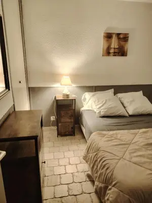 a bedroom with a bed and a table with a lamp at 480 Rue de la Hune in Gruissan