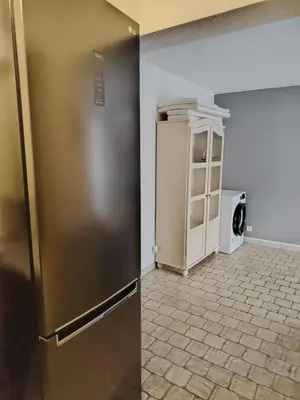 a kitchen with a refrigerator and a tile floor at 480 Rue de la Hune in Gruissan