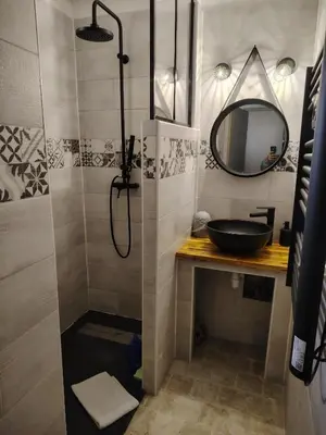 a bathroom with a sink and a shower with a mirror at 480 Rue de la Hune in Gruissan