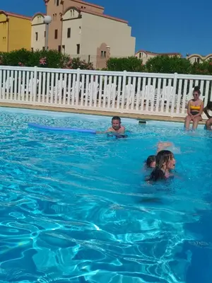 a group of people swimming in a swimming pool at logis 194 in Gruissan