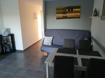 a living room with a blue couch and a table at logis 194 in Gruissan