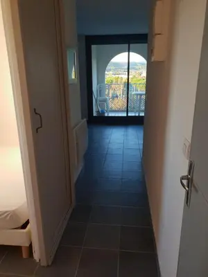 a hallway with a view of a room with a balcony at logis 194 in Gruissan