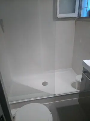 a white bathroom with a toilet and a shower at logis 194 in Gruissan