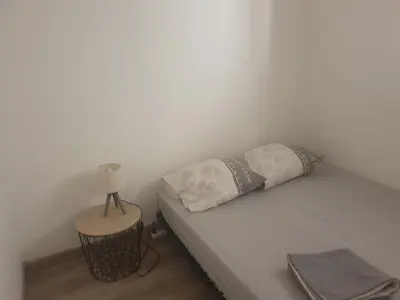 a bed with two pillows and a lamp on a table at logis 149 in Gruissan