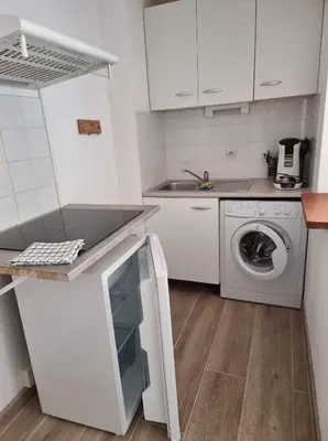 a white kitchen with a washing machine and a washer at logis 149 in Gruissan