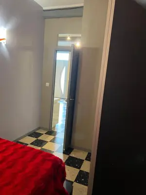 a bedroom with a red bed and a doorway at maison des corbieres in Conilhac-Corbières