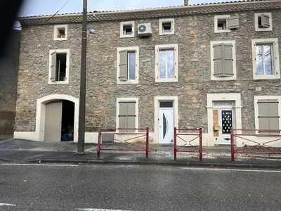 a brick building with two red benches in front of it at maison des corbieres in Conilhac-Corbières