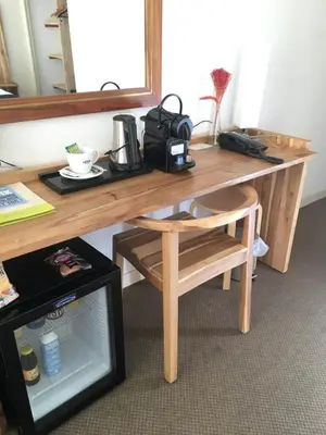 a wooden desk with a coffee maker and a chair at Logis Hôtel de France & Restaurant Pamiers in Pamiers