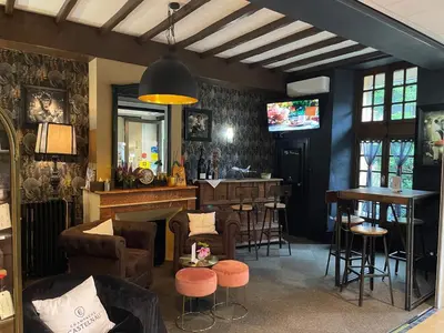 a restaurant with a bar with chairs and a table at Logis Hôtel de France & Restaurant Pamiers in Pamiers