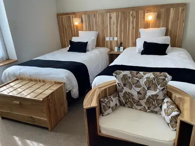 a hotel room with two beds and a chair at Logis Hôtel de France & Restaurant Pamiers in Pamiers