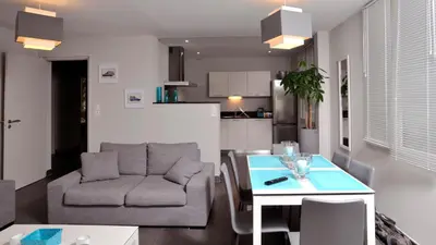 a living room with a couch and a table at Appartement Le Saint Nazaire - Les Balcons de la Cité in Carcassonne