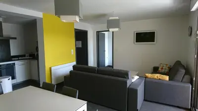 a living room with a couch and a table at Appartement Le Saint Nazaire - Les Balcons de la Cité in Carcassonne