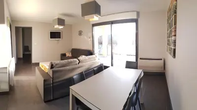 a living room with a couch and a table at Appartement Le Saint Nazaire - Les Balcons de la Cité in Carcassonne