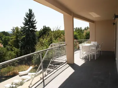 a balcony of a house with a table and chairs at Appartement Le Saint Nazaire - Les Balcons de la Cité in Carcassonne