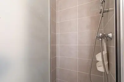 a bathroom with a shower with a glass door at Le Narbona in Narbonne