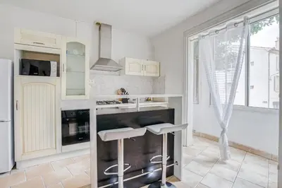 a kitchen with white cabinets and white appliances at Le Narbona in Narbonne