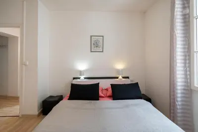 a bedroom with a large bed with two lamps at Le Narbona in Narbonne