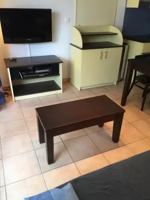 a living room with a coffee table and a flat screen tv at Résidence les jardins du phoebus appartement in Gruissan