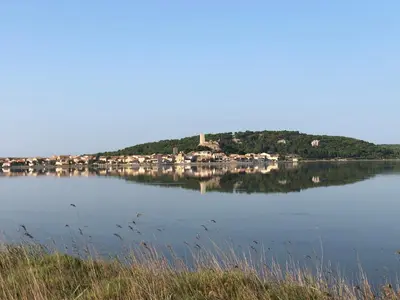 a large body of water with houses on a hill at Résidence les jardins du phoebus appartement in Gruissan