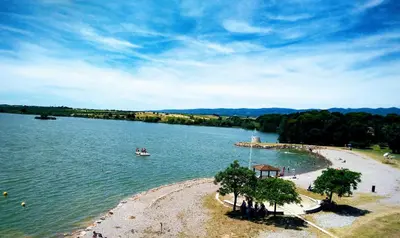 a large body of water with a boat in it at La Maison des Palmiers in Homps