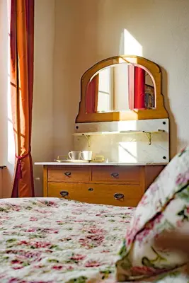 a bedroom with a dresser with a mirror and a bed at La Maison des Palmiers in Homps