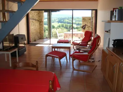 a living room with red chairs and a table at Gîte du Tarbésou in Régat
