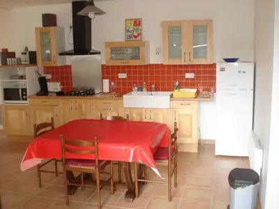 a kitchen with a table with a red table cloth on it at Gîte du Tarbésou in Régat