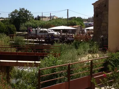 a bridge over a body of water with a fence at Ile du Gua Suites in Narbonne
