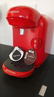 a red toaster sitting on top of a table at 