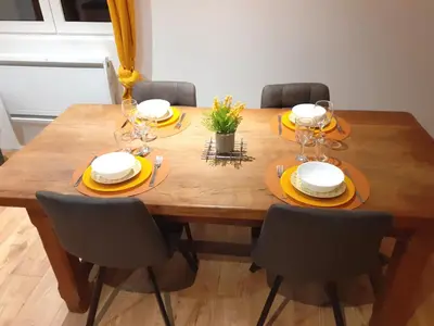 a wooden table with chairs and plates and glasses on it at 