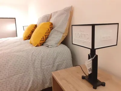 a bed with yellow pillows and a sign on a table at 