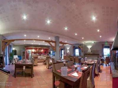 a dining room with tables and chairs in a restaurant at La Ferme O Délices in Mazères