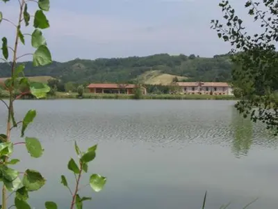 a large body of water with houses in the background at La Ferme O Délices in Mazères