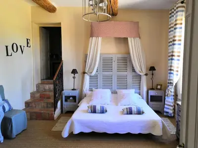 a bedroom with a large white bed with two pillows at Chambre d'Hôtes au Domaine du Soleil Couchant in Saint-André-de-Roquelongue