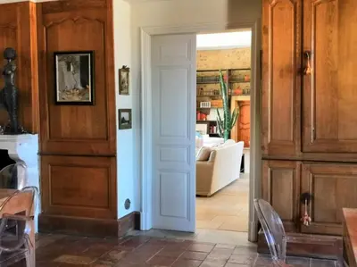 a hallway with a white door and a living room at Chambre d'Hôtes au Domaine du Soleil Couchant in Saint-André-de-Roquelongue