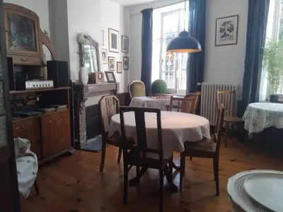 a dining room with a table and chairs and a room with a fireplace at Maison Rives - Village du Livre de Montolieu in Montolieu