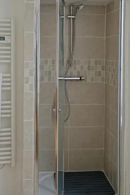 a shower with a glass door in a bathroom at Maison Rives - Village du Livre de Montolieu in Montolieu